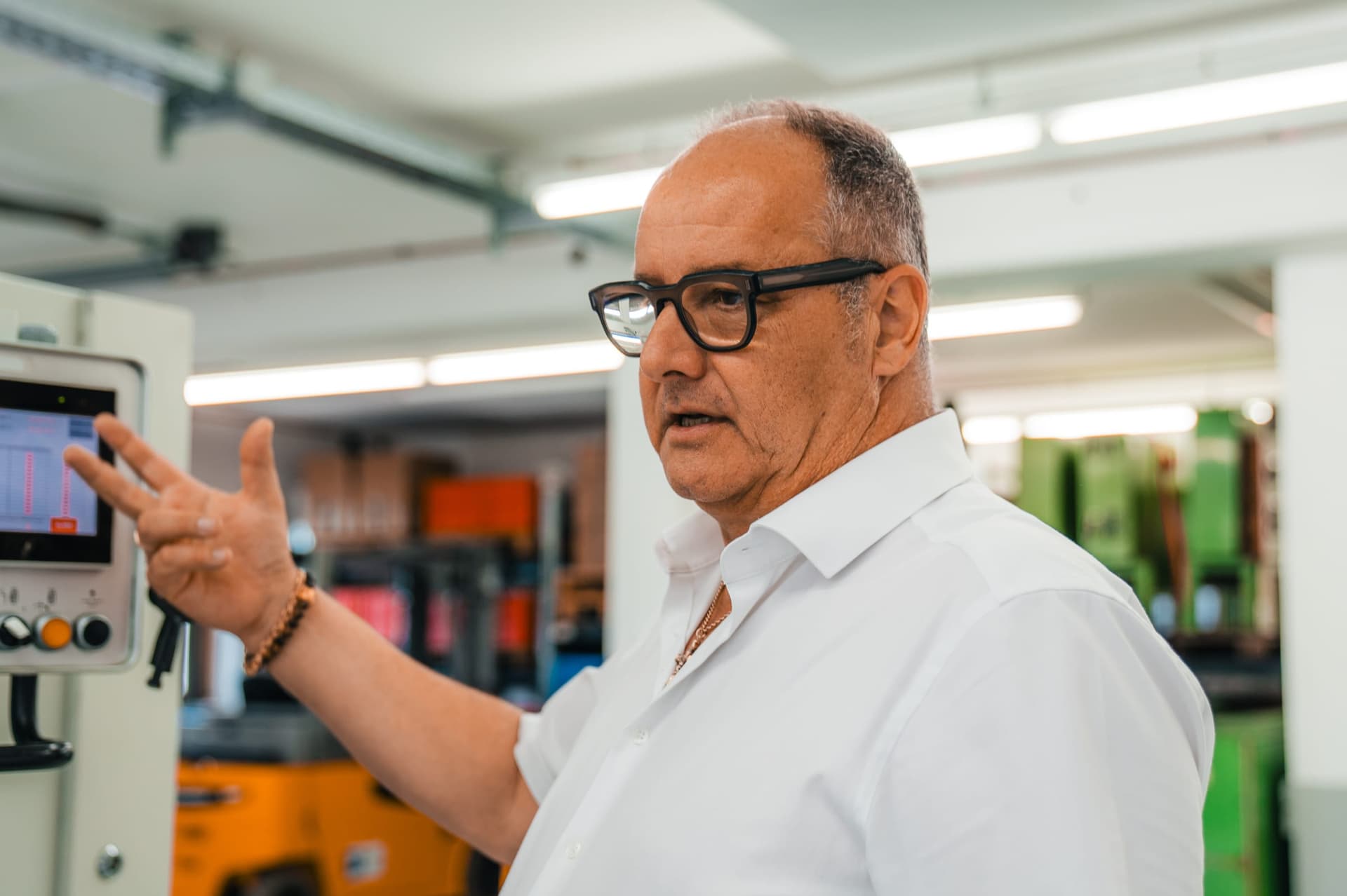 Josef Pöllmann erklärt eine Maschine in der Halle