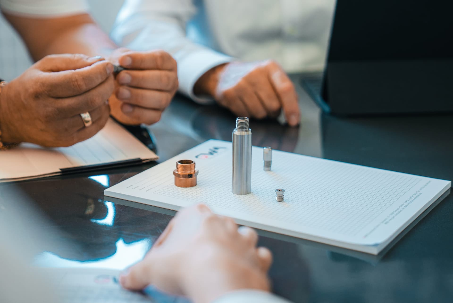 Technische Beratung mit Drehteilen auf dem Tisch